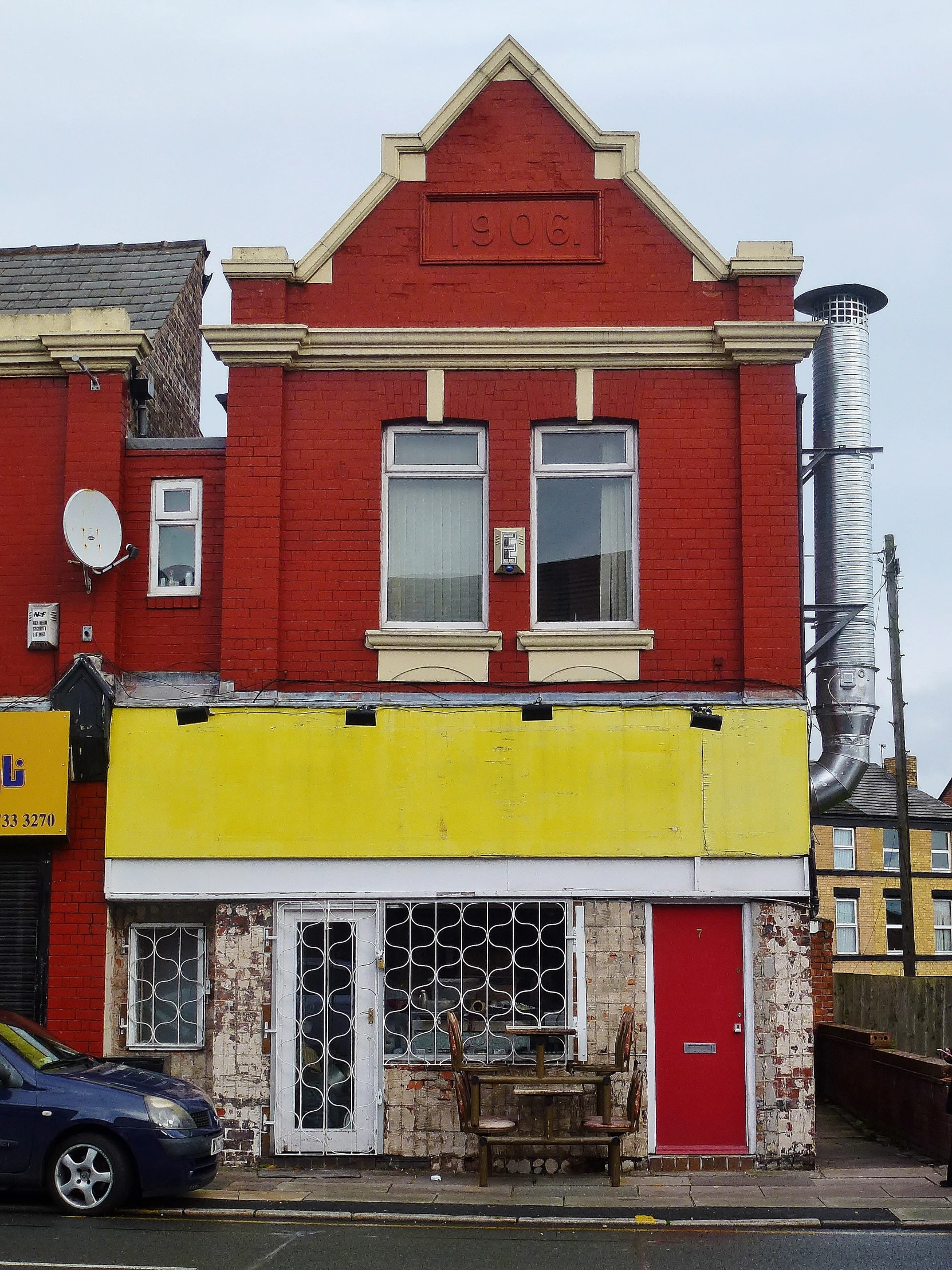 a building with graffiti and boarded windows near an intersection