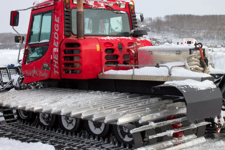 an electric snowplow with the front end being loaded onto its car