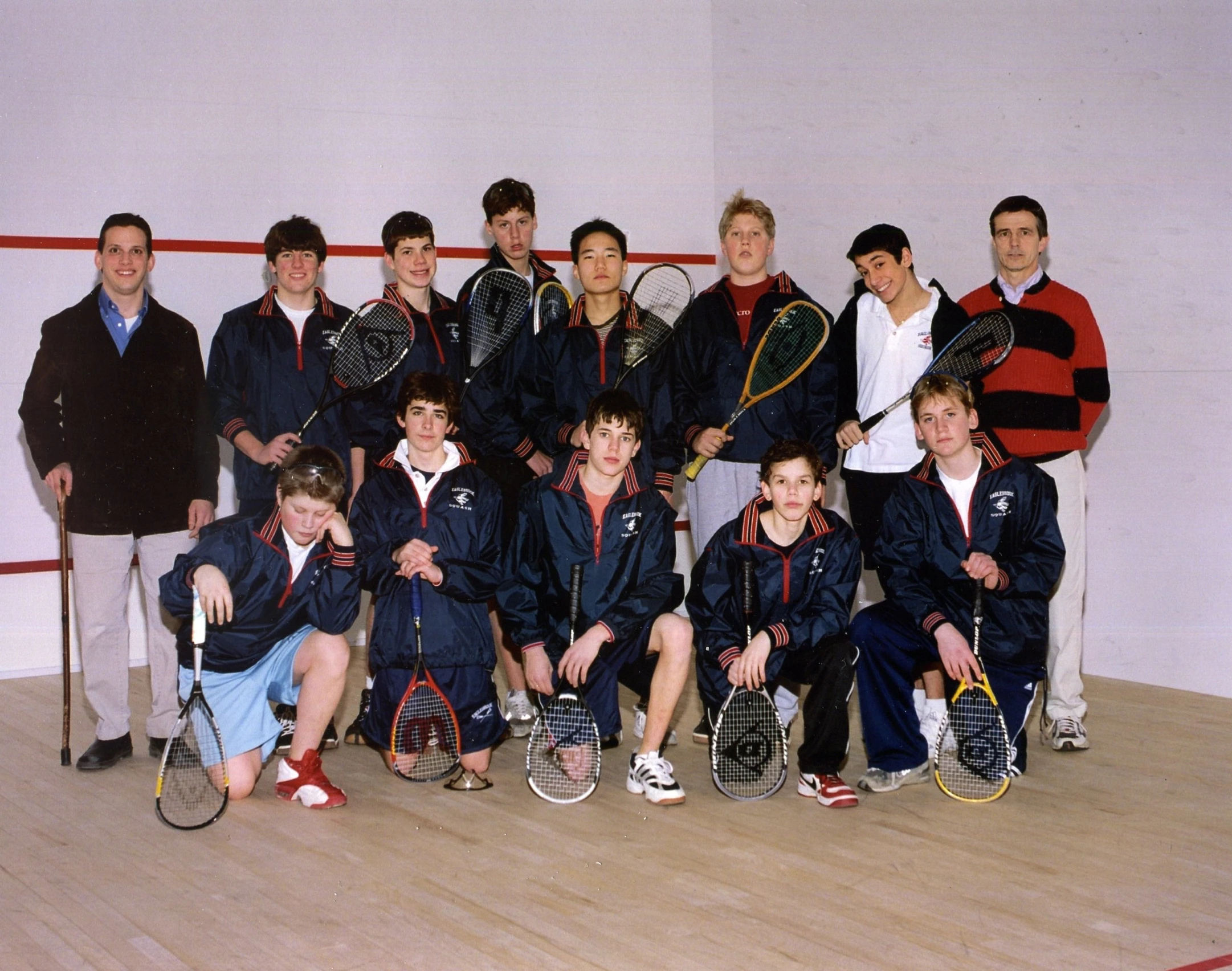 a group of people with tennis racquets sitting on the floor