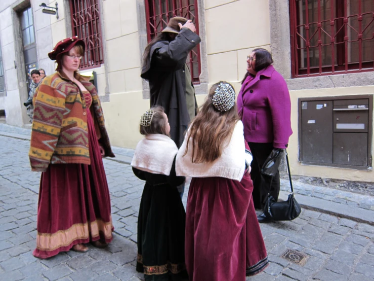 several people stand around on a cobblestone street