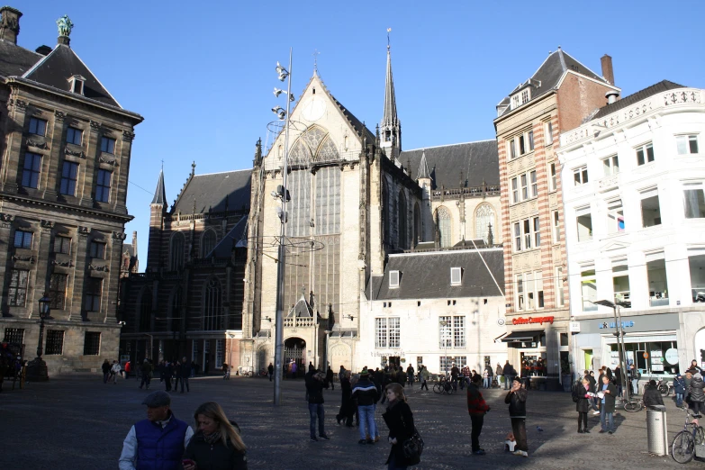 a group of people walking around an open city square