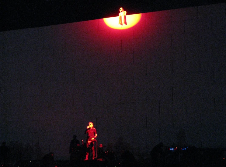 a person standing under an orange and red light