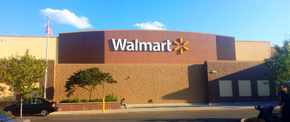 people walking outside a walmart store with a building in the background