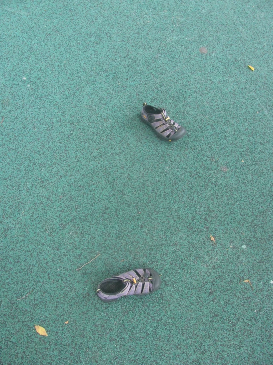 pair of shoes in sand area with green paint