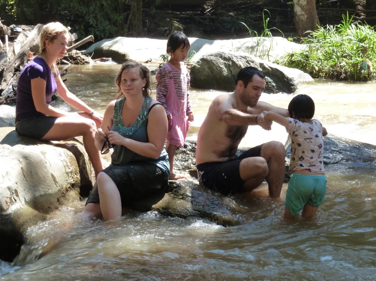 group of people sitting on rock and taking pictures