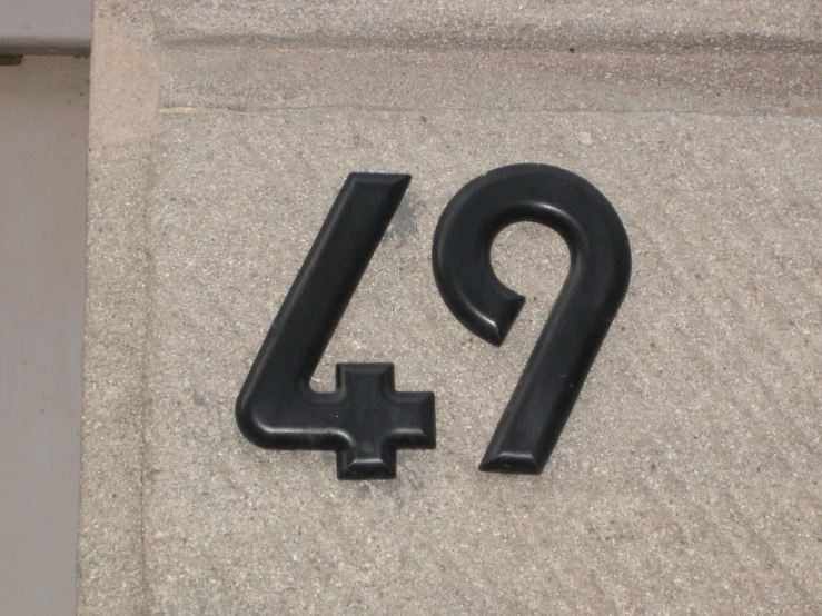 the number nine is lying next to a smaller black object