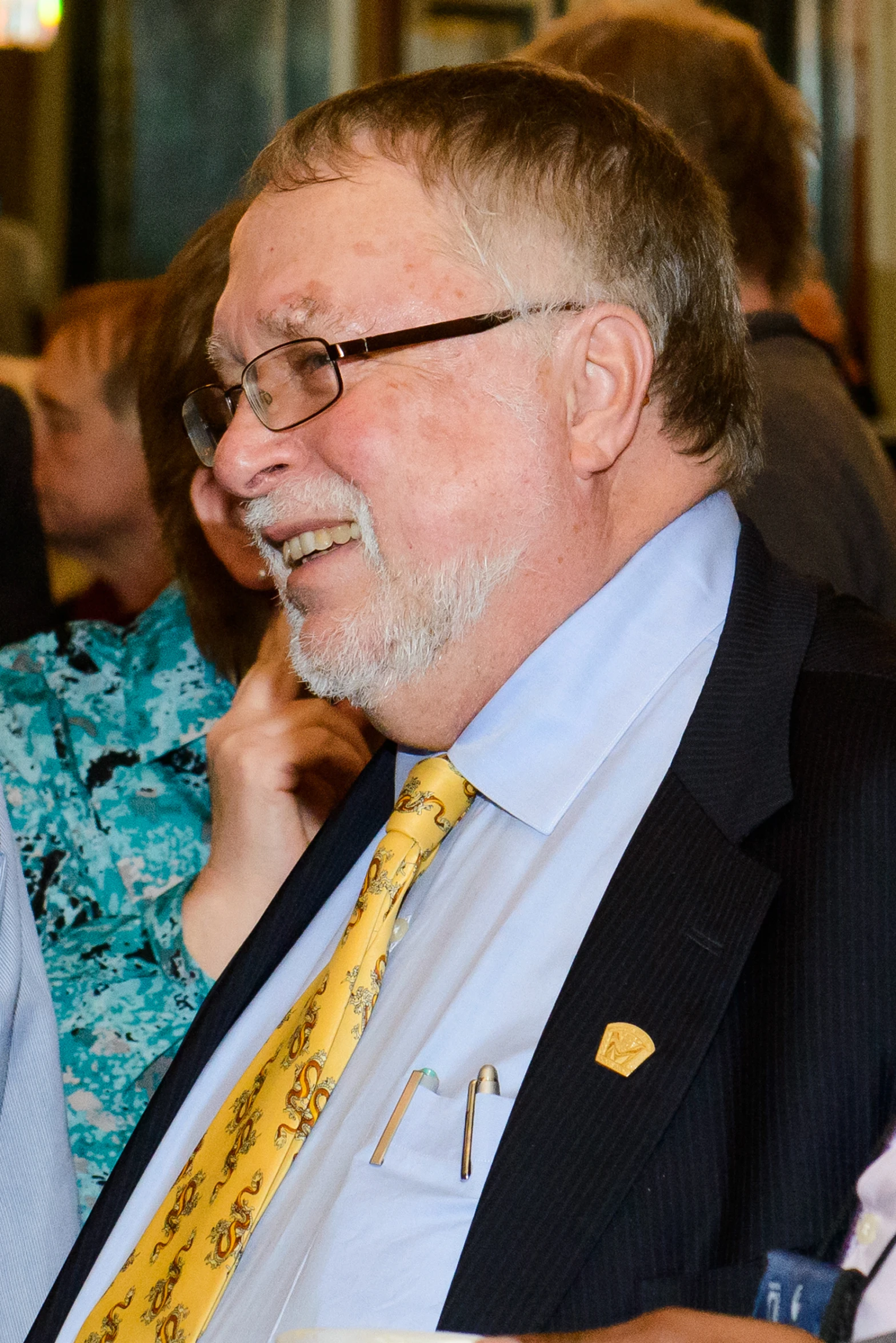 a man wearing glasses, a suit and a yellow tie