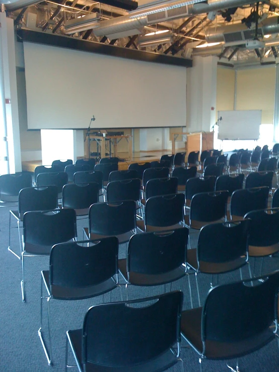 rows of chairs sit in a lecture hall