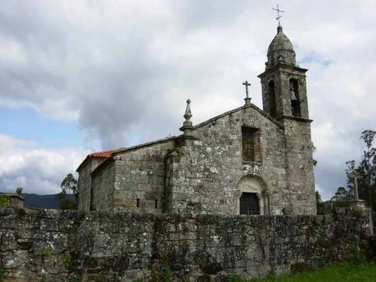 an old church in an overgrown area surrounded by moss