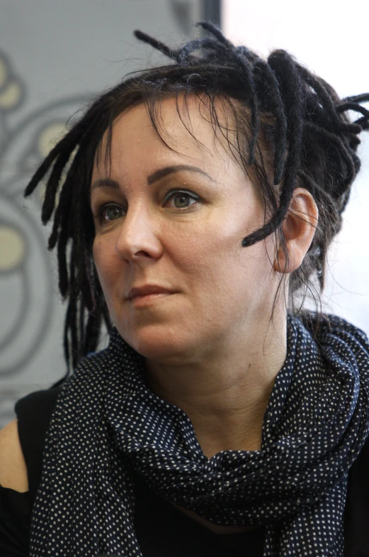 a woman with dreadlocks looking directly into the camera