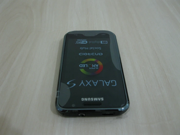 a smart phone is sitting on the table with many symbols and logos