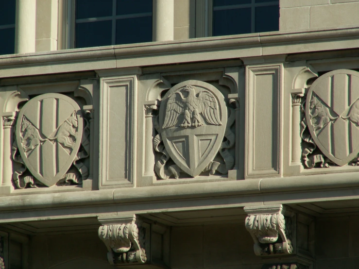 a building with two emblems above a coat of arms