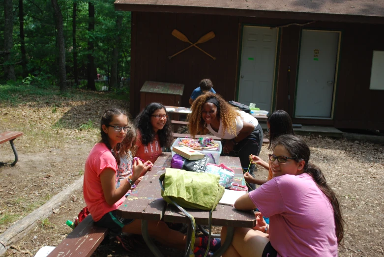 a group of s sitting around a picnic table