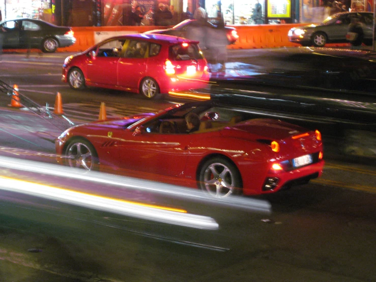 two red cars on the road with blurry traffic