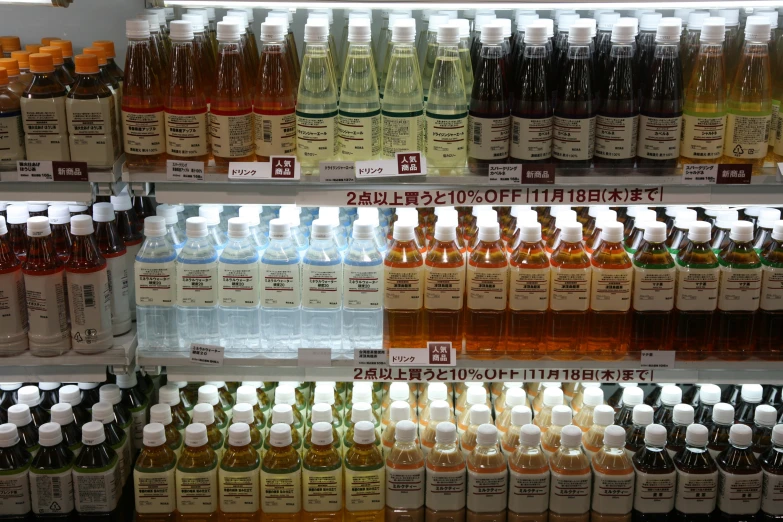 bottled drinks sit for sale on a shelf in a store