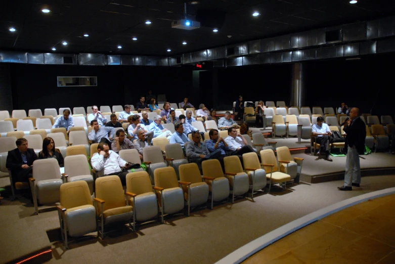 an empty auditorium filled with people standing and sitting