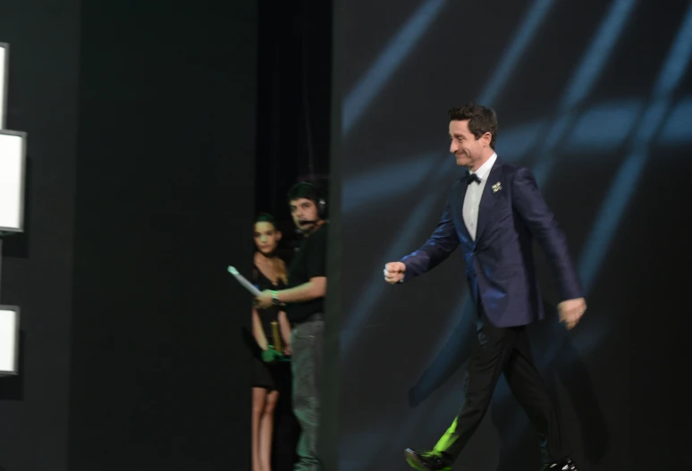 a man in a suit is walking down the runway