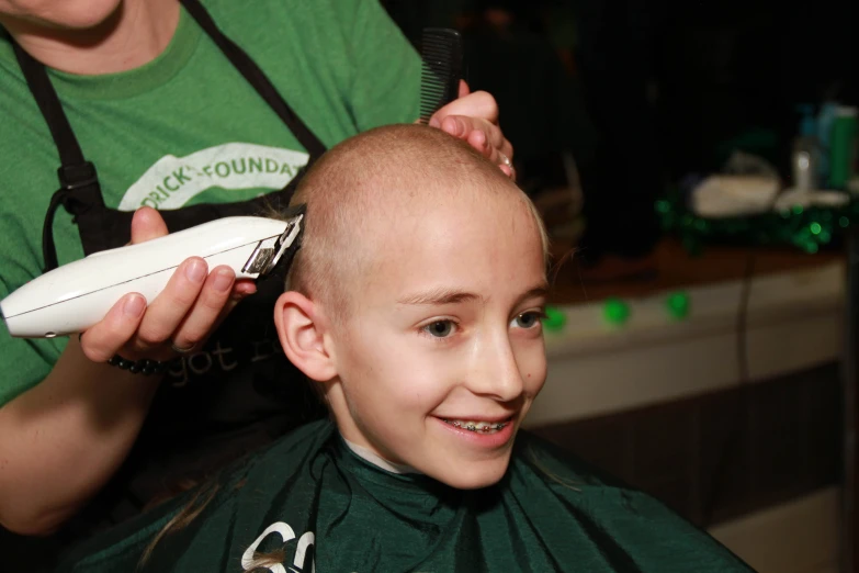 a girl getting her hair cut and styled by another person