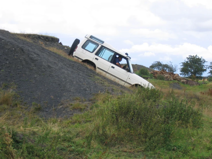 a white car sitting on top of a hill