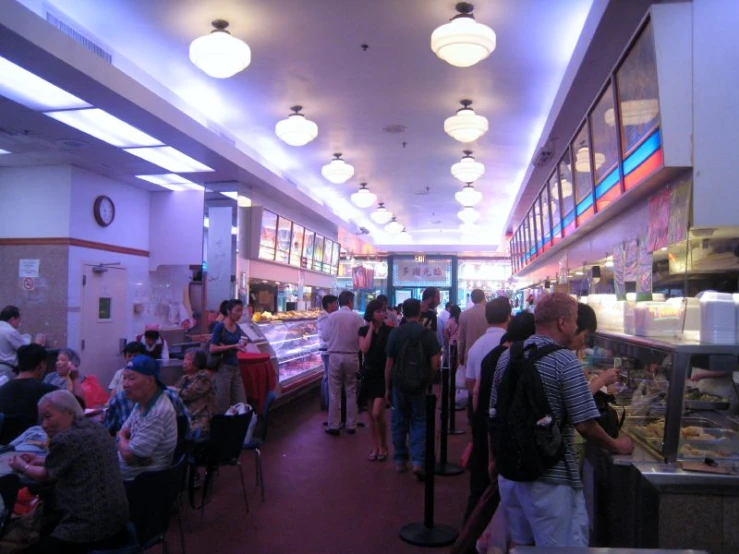 a bunch of people standing around in a restaurant