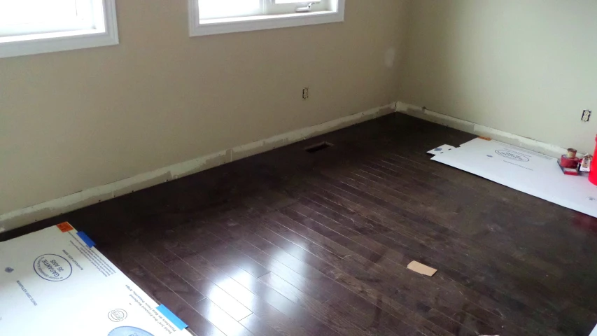 empty room with hard wood floors, new windows, paint and cardboard