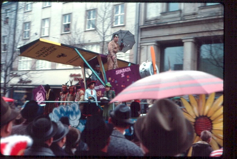 an outdoor stage with people and umbrellas on a city street