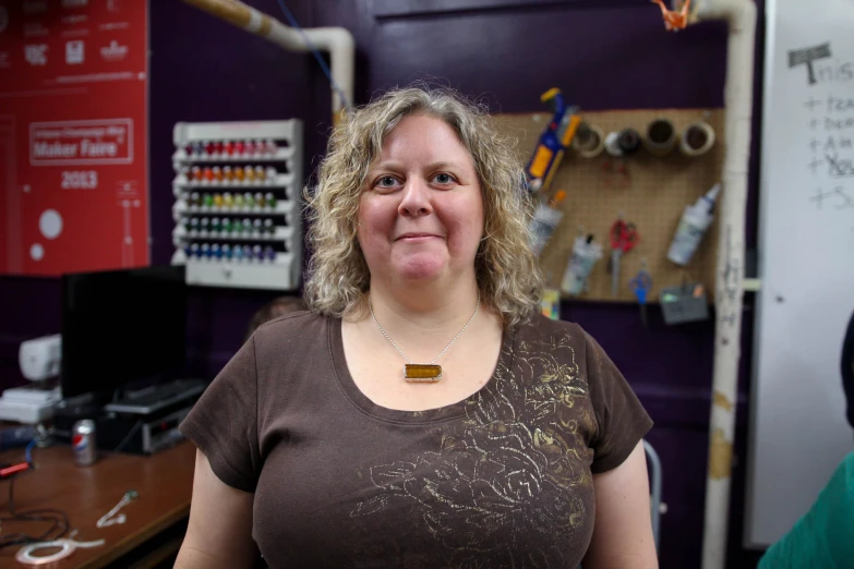 a person standing next to a purple wall and lots of craft supplies
