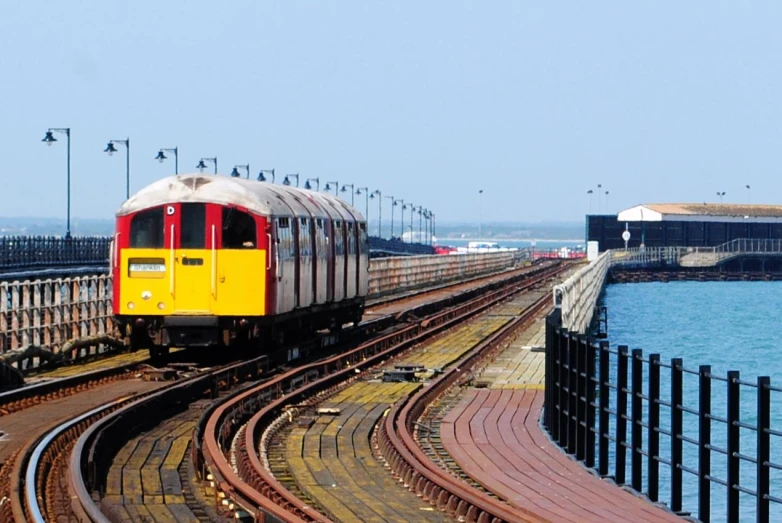 a passenger train is on the tracks by water