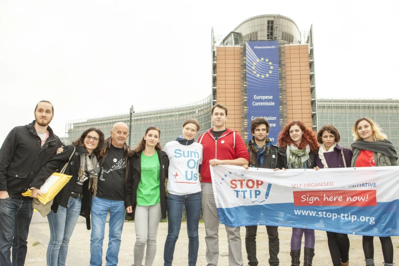 group of young women holding up signs in front of a large building