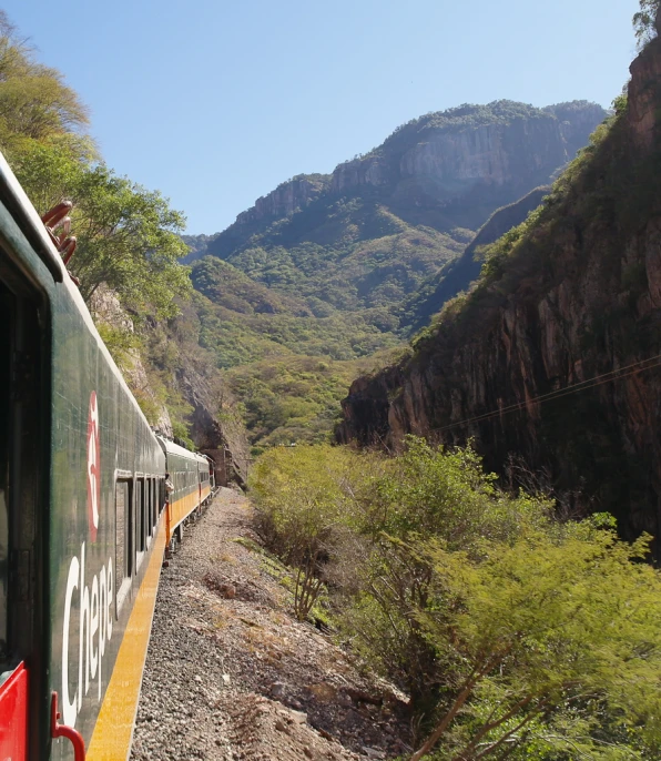 a train travelling through the mountains on a scenic train journey