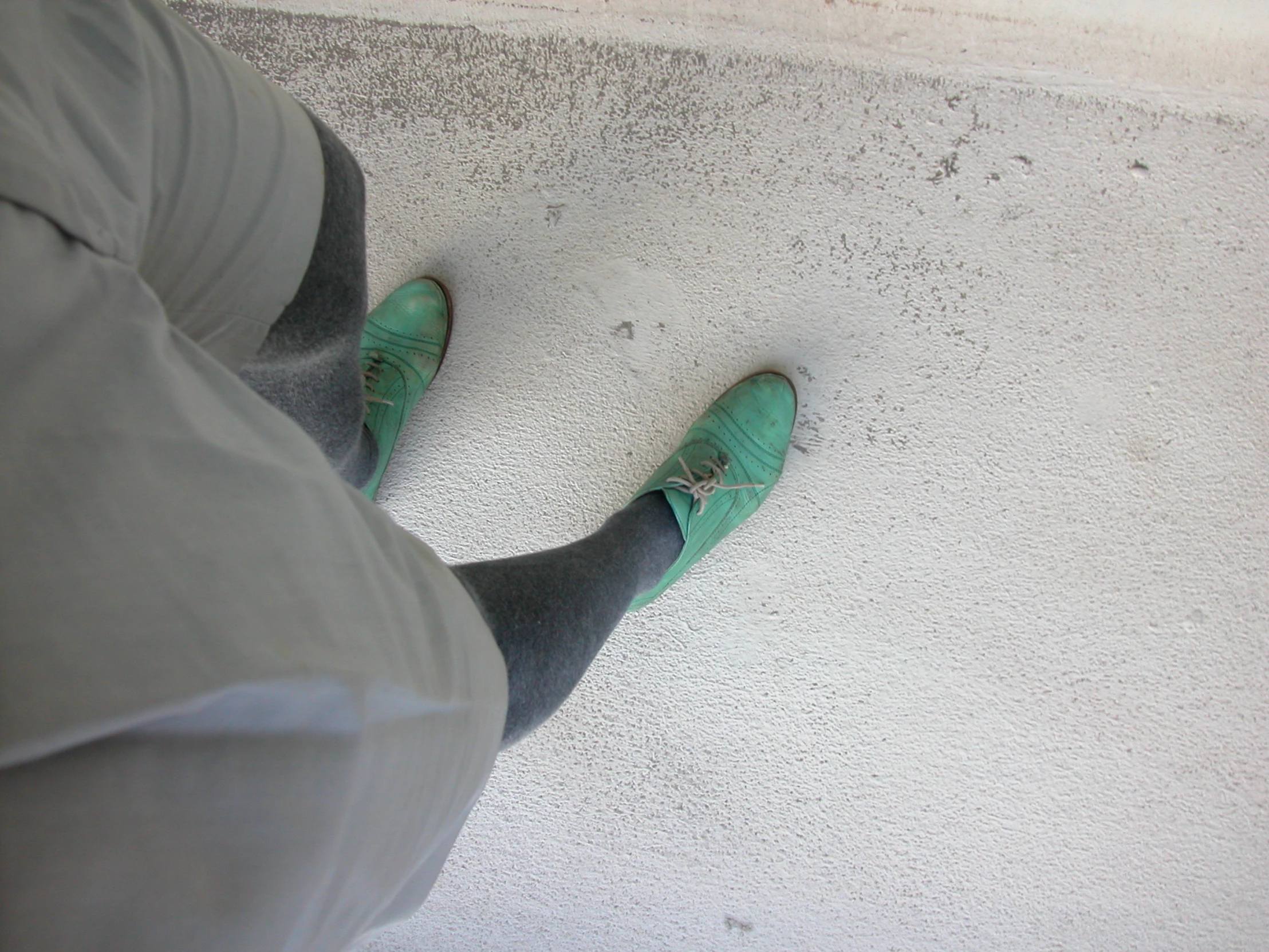 a persons feet, standing on a gray surface