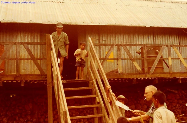 a man is standing on a stage as other people look on