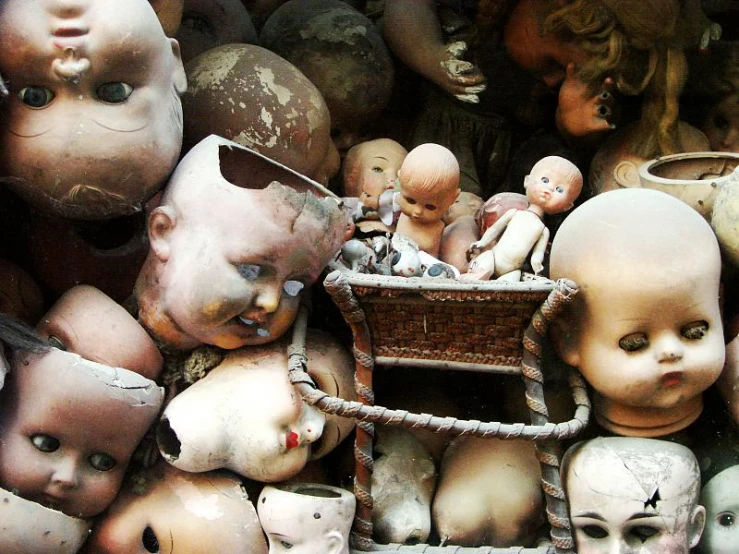 various sculptures of dolls sitting in a pile