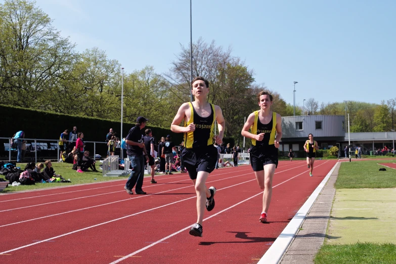 a group of young men run down a track