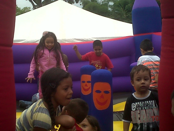 children are gathered around in an inflatable toy