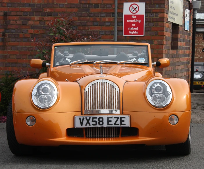 an orange car with a license plate that reads vy86 eze