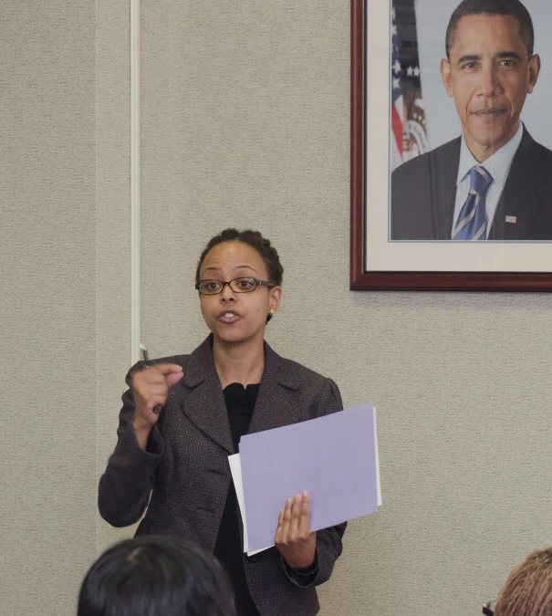 a woman speaking at a small gathering for obama