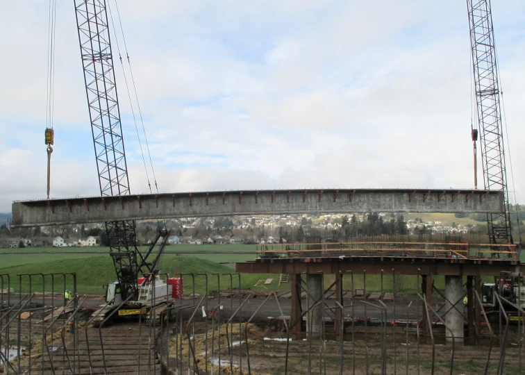 a crane lifts a bridge and a bulldozer