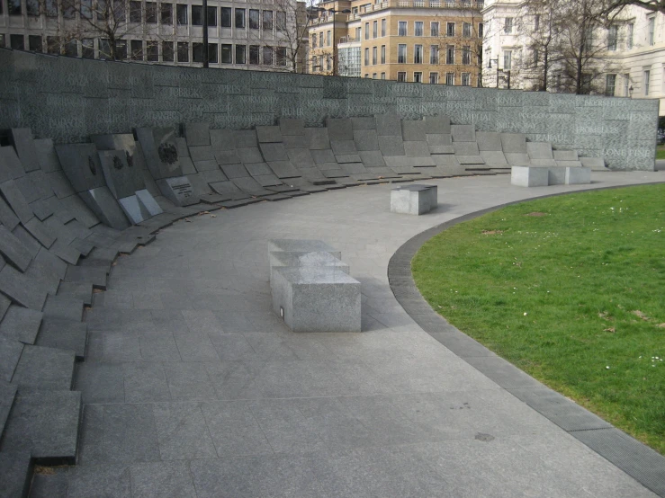 a park with benches and a green grass field