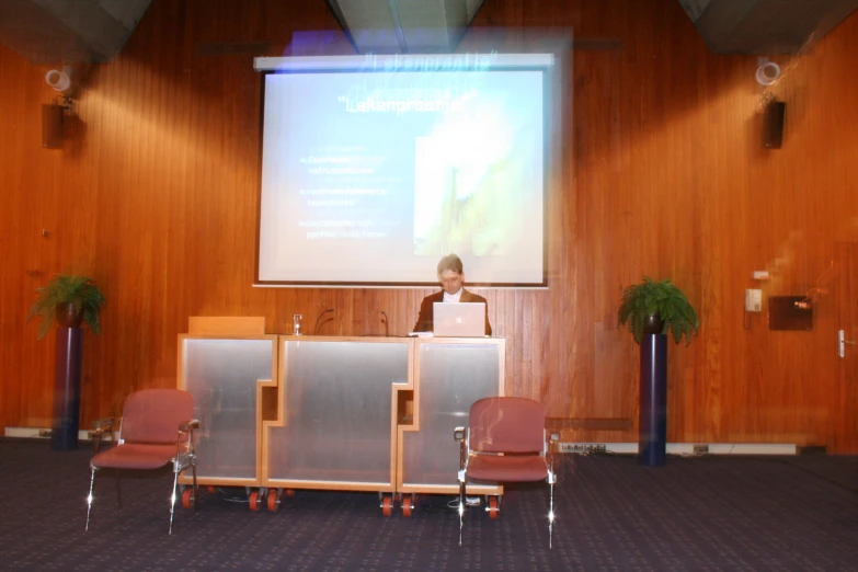 a man standing at a podium next to a podium on a stage