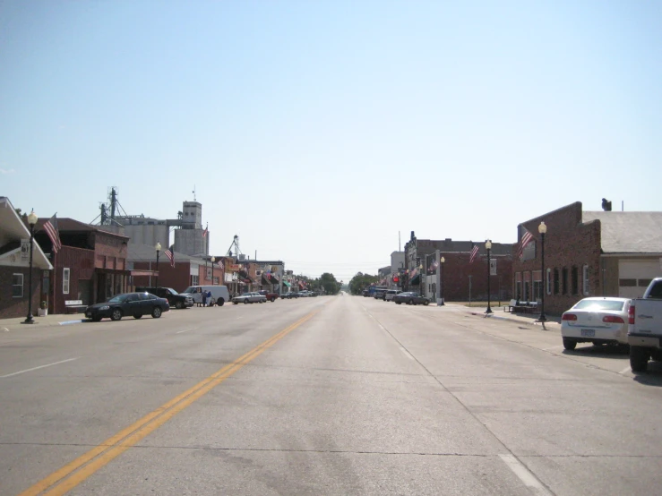 the view of a town street and some parked cars