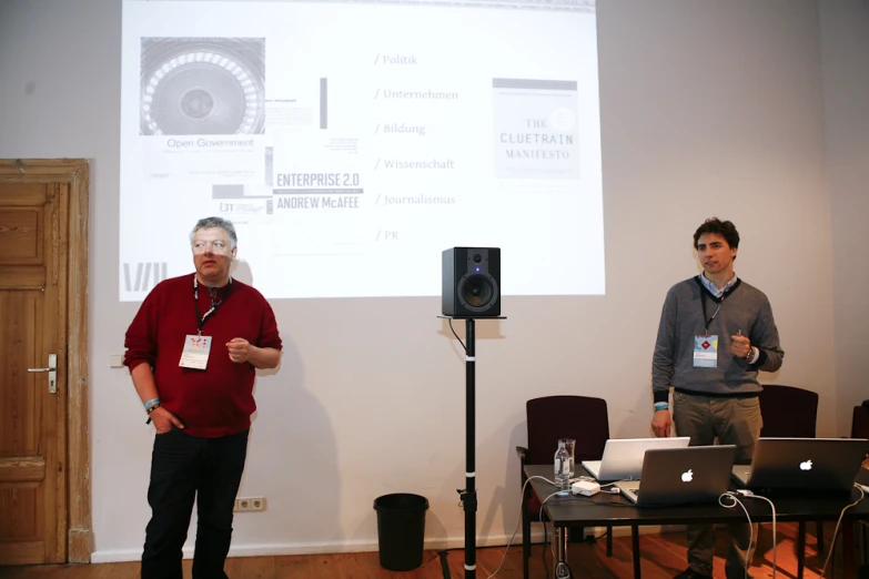 a group of men standing in front of a projector screen