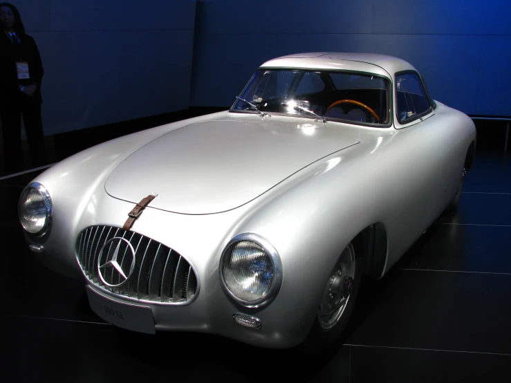 an old, silver sports car in a dark room