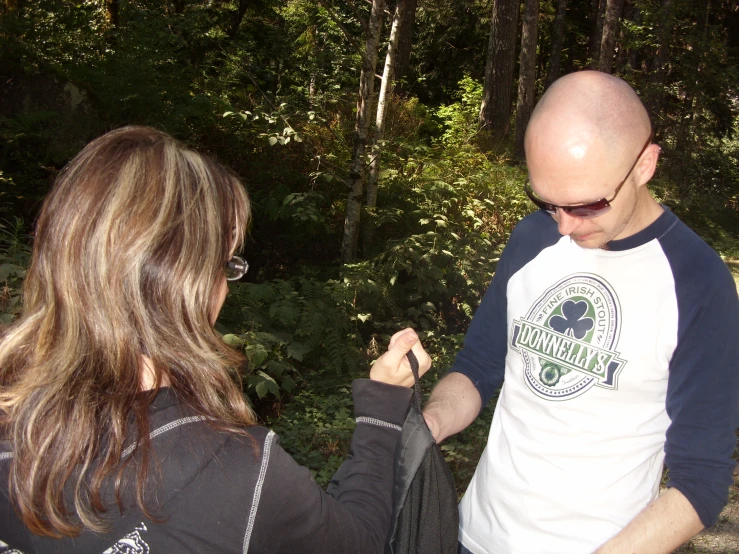 an old bald man fixes a young woman's hair