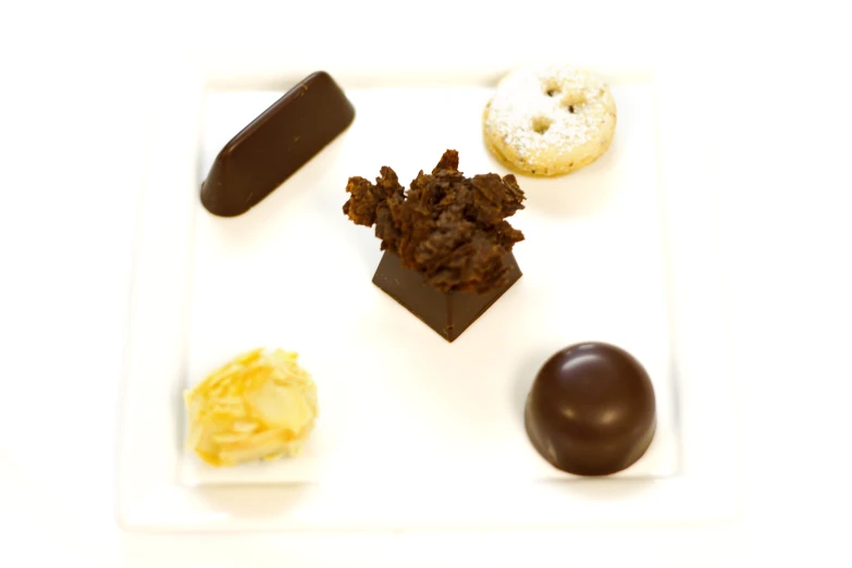 several pastries and a chocolate doughnut on a square plate