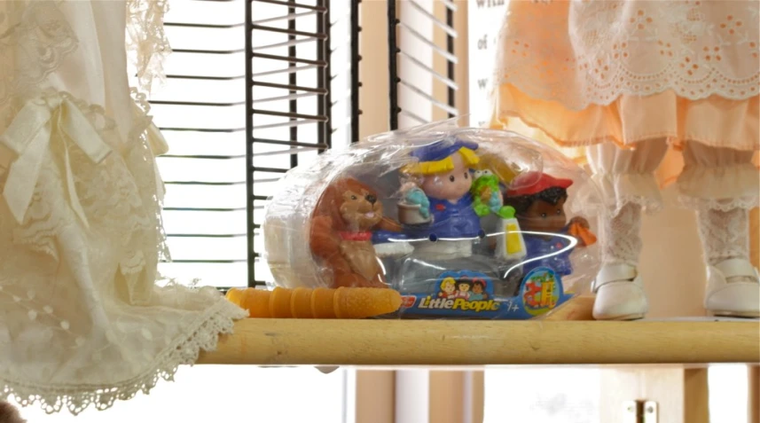 the toy bear and two dolls are in their plastic playhouse