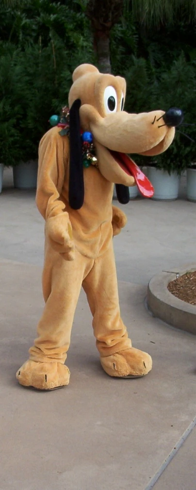 an elephant mascot holding a red disc standing next to two plants