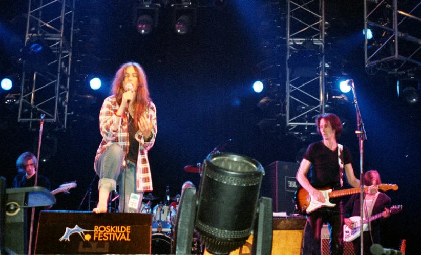 two men on stage are singing in front of a crowd