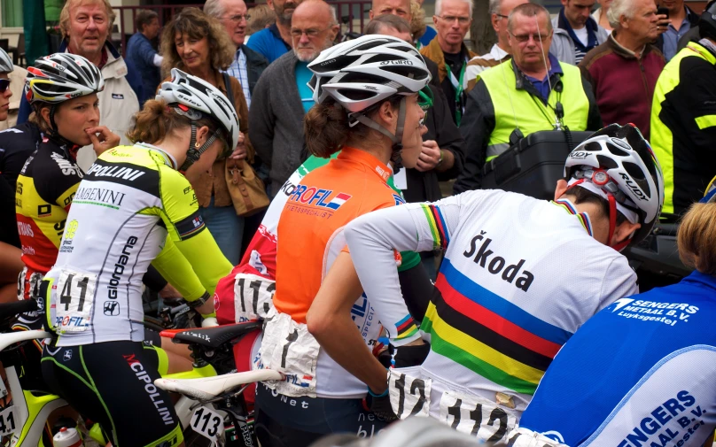 people with colorful outfits are riding their bicycles and talking to each other