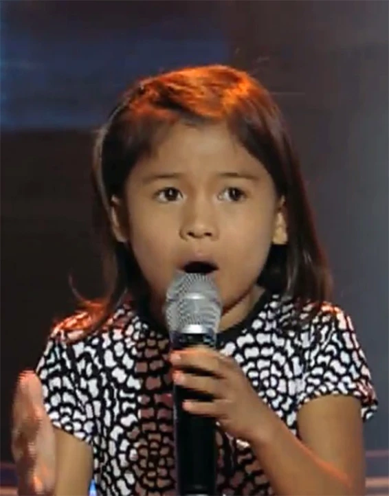 an image of girl singing into a microphone